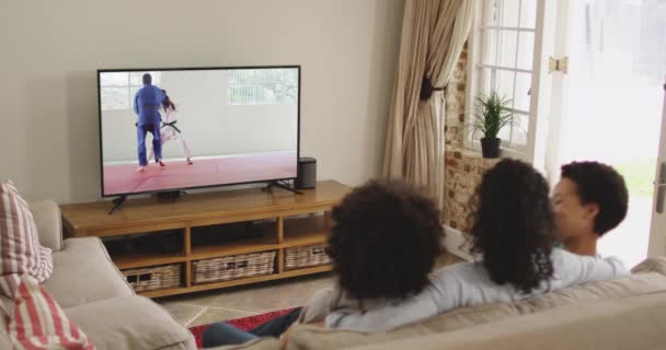 Mutlu Bir Ailenin Evde Oturup Televizyonda Judo Maçı Izlemesinin Birleşimi — Stok video