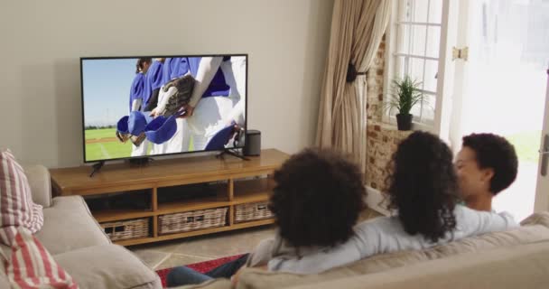 Mutlu Bir Ailenin Evde Oturup Televizyonda Beyzbol Maçı Izlemesinin Birleşimi — Stok video