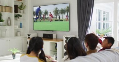 Mutlu bir ailenin evde oturup TV 'de hokey maçı izlemesinin birleşimi. spor, rekabet, eğlence ve teknoloji konsepti dijital olarak oluşturulmuş video.