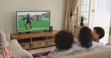 Mutlu bir ailenin evde oturup TV 'de hokey maçı izlemesinin birleşimi. spor, rekabet, eğlence ve teknoloji konsepti dijital olarak oluşturulmuş video.