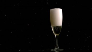 Şampanya kadehinin üzerine düşen beyaz lekelerin animasyonu. Yeni yıl partisi ve kutlama konsepti dijital olarak oluşturulmuş video.