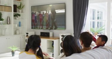 Mutlu bir ailenin evde oturup TV 'de hokey maçı izlemesinin birleşimi. spor, rekabet, eğlence ve teknoloji konsepti dijital olarak oluşturulmuş video.