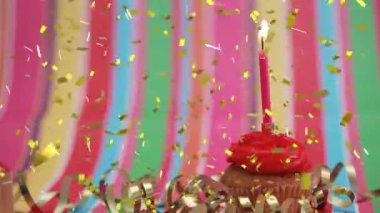 Doğum günü pastasının üzerine yanan mumun üzerine düşen altın konfetilerin animasyonu. doğum günü, kutlama, parti, gelenek ve olay konsepti dijital olarak oluşturulmuş video.