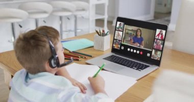 Liseli çocuk evde online ders için dizüstü bilgisayar kullanıyor. Çeşitli öğretmenler ve sınıflar ekranda. küresel iletişim teknolojisi ve çevrimiçi ilköğretim konsepti, dijital kompozit video.