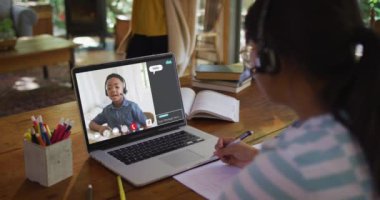 Liseli kız, meslektaşı ve internet sohbeti ile evde online ders için dizüstü bilgisayar kullanıyor. küresel iletişim teknolojisi ve çevrimiçi ilköğretim konsepti, dijital kompozit video.