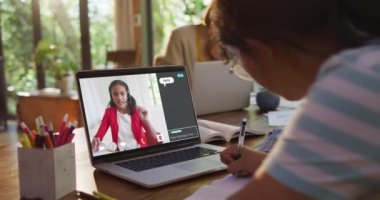 Kızın evde online ders için dizüstü bilgisayar kullandığı ve kızın ekranda elini kaldırdığı birleşik video. küresel iletişim teknolojisi ve çevrimiçi ilköğretim konsepti, dijital olarak oluşturulmuş video.