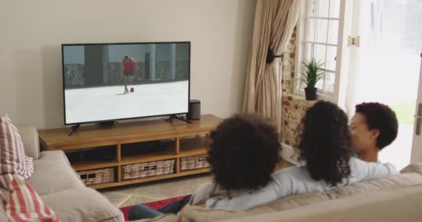 Mutlu Bir Ailenin Evde Oturup Televizyonda Koşan Atletizmleri Izlemesinin Birleşimi — Stok video