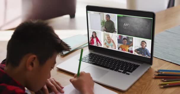 家庭でのオンラインレッスンのためにラップトップを使用して学校の少年 画面上の多様な教師とクラスと グローバルコミュニケーション技術とオンライン初等教育の概念デジタル複合ビデオ — ストック動画