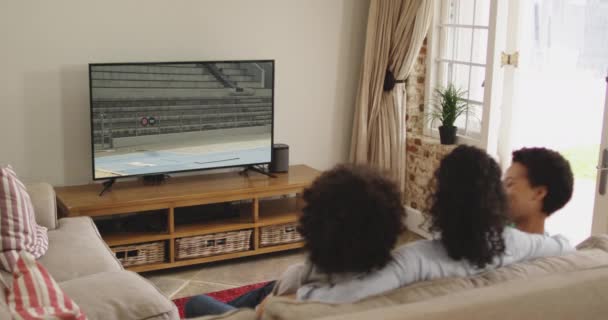 Composto Família Feliz Sentados Casa Juntos Assistindo Atletismo Salto Distância — Vídeo de Stock