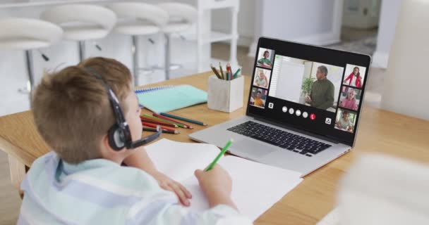 家庭でのオンラインレッスンのためのラップトップを使用して少年の複合体は 画面上の多様な教師とクラスと 地球規模の通信技術とオンライン初等教育の概念デジタルで生成されたビデオ — ストック動画