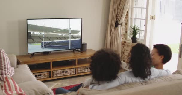 Composto Família Feliz Sentados Casa Juntos Assistindo Atletismo Salto Altura — Vídeo de Stock