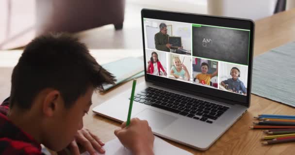 家庭でのオンラインレッスンのためにラップトップを使用して学校の少年 画面上の多様な教師とクラスと グローバルコミュニケーション技術とオンライン初等教育の概念デジタル複合ビデオ — ストック動画
