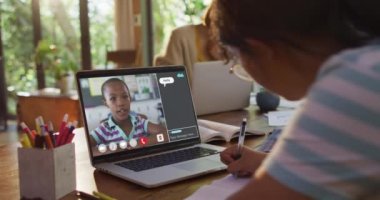 Liseli kız, meslektaşı ve internet sohbeti ile evde online ders için dizüstü bilgisayar kullanıyor. küresel iletişim teknolojisi ve çevrimiçi ilköğretim konsepti, dijital kompozit video.