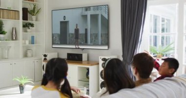 Mutlu bir ailenin evde oturup TV 'de atletizm maçı izlemesinin birleşimi. spor, rekabet, eğlence ve teknoloji konsepti dijital olarak oluşturulmuş video.