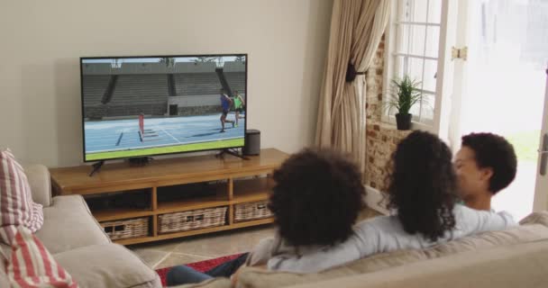 Compuesto Familia Feliz Sentados Casa Juntos Viendo Correr Evento Atletismo — Vídeos de Stock