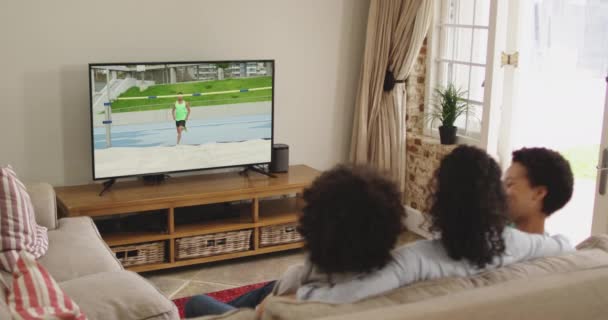 Composto Família Feliz Sentados Casa Juntos Assistindo Atletismo Salto Altura — Vídeo de Stock