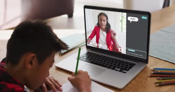 自宅でオンラインレッスンのためにラップトップを使用して学校の少年 彼の同僚と画面上のWebチャットと グローバルコミュニケーション技術とオンライン初等教育の概念デジタル複合ビデオ — ストック動画