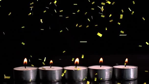 Animation Von Goldenem Konfetti Das Über Brennende Teelichterkerzen Auf Schwarzem — Stockvideo