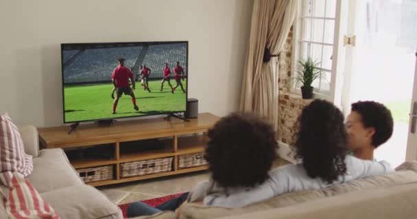 Composite Famille Heureuse Assis Maison Ensemble Regarder Match Rugby Télévision — Video