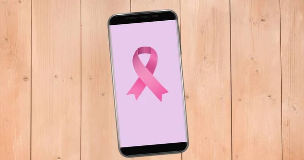 Composition of pink ribbon logo on the smartphone screen. breast cancer positive awareness campaign concept digitally generated image.