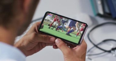 Erkek doktorun akıllı telefondan hokey maçı izlemesinin birleşimi. spor, rekabet, eğlence ve teknoloji konsepti dijital olarak oluşturulmuş video.