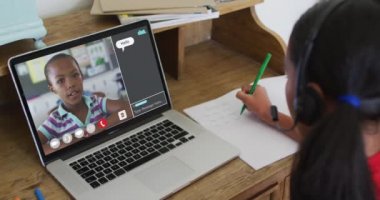 Liseli kız evde online ders için dizüstü bilgisayar kullanıyor, kız kıza konuşuyor ve ekranda sohbet ediyor. iletişim teknolojisi ve çevrimiçi ilköğretim konsepti, dijital kompozit video.