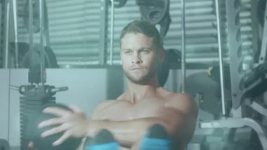 Spor salonunda egzersiz yapan güçlü bir adamın üzerinde parlayan noktaların animasyonu. spor, fitness ve aktif yaşam tarzı konsepti dijital olarak oluşturulmuş video.