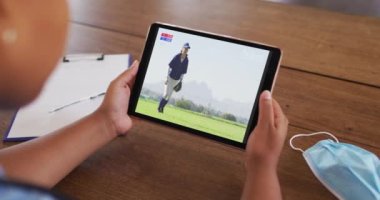 Masada yüz maskesi takmış, tablette beyzbol maçı izleyen bir kadın. covid 19 konseptinde dijital olarak üretilen spor, rekabet, eğlence ve teknoloji.