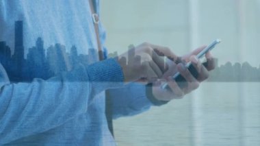 Şehir manzarası üzerinde akıllı telefon kullanan bir adamın animasyonu. küresel iş, iletişim ve finans kavramı dijital olarak oluşturulmuş video.