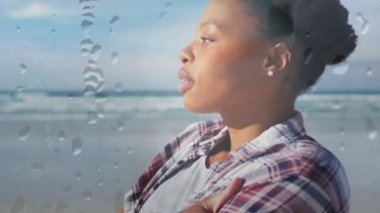 Afrika kökenli Amerikalı bir kadının damlacıklar üzerinde plajda dinlenmesi. Mutlu tatiller ve boş zaman, dijital ortamda oluşturulan video.