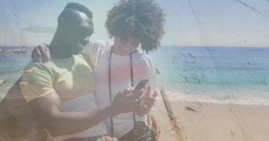 Deniz aşırı sahillerde akıllı telefon kullanan mutlu Afro-Amerikan çiftin animasyonu. Doğa, tatil ve yaz dijital olarak üretilen video.