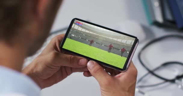 Compuesto Médico Masculino Viendo Partido Rugby Teléfono Inteligente Deportes Competencia — Vídeo de stock