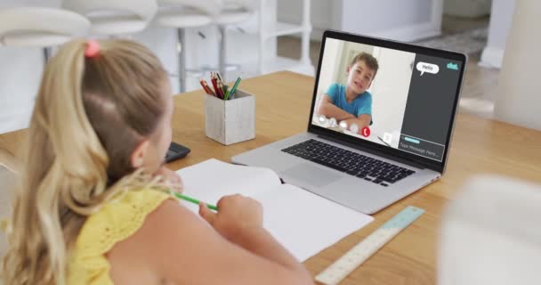 家庭でのオンラインレッスンのためのラップトップを使用して女子高生 画面上で男の子の話やWebチャットと 通信技術とオンライン初等教育の概念デジタル複合ビデオ — ストック動画