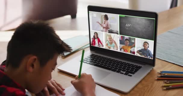 男中学生在家里用笔记本电脑上网上课 屏幕上有各种各样的老师和班级 通信技术和在线初等教育概念 数字复合录像 — 图库视频影像