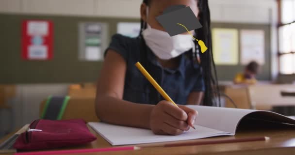 毕业帽象征着对在小学学习的戴着面具的非洲裔美国女孩的反对 回到学校和教育的概念 — 图库视频影像