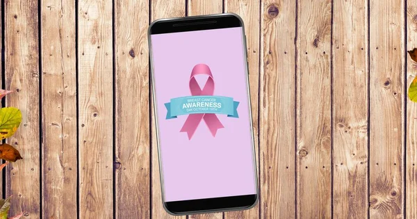 Composition of pink ribbon logo and breast cancer text on the smartphone screen. breast cancer positive awareness campaign concept digitally generated image.