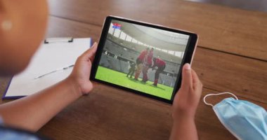 Masada maske takmış bir kadının tablette rugby maçı izlemesi. covid 19 konseptinde dijital olarak üretilen spor, rekabet, eğlence ve teknoloji.