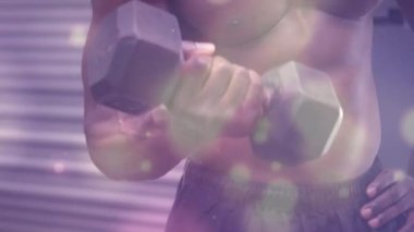 Spor salonunda egzersiz yapan güçlü bir adamın üzerinde parlayan noktaların animasyonu. spor, fitness ve aktif yaşam tarzı konsepti dijital olarak oluşturulmuş video.