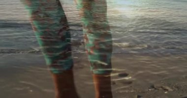 Sahilde, güneşin üzerinde yürüyen insan bacakları canlandırması. Tatiller ve boş zaman, dijital olarak üretilen video.