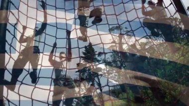 Yunanca bayrağın askerlerin açık havada tırmanma egzersizlerinin üzerine konması. Vatanseverlik ve silahlı kuvvetler kavramı dijital olarak oluşturulmuş video.