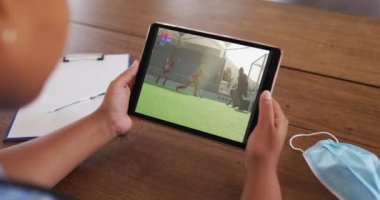 Masada maske takmış, tablette hokey maçı izleyen bir kadın. covid 19 konseptinde dijital olarak üretilen spor, rekabet, eğlence ve teknoloji.