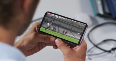 Erkek doktorun akıllı telefondan ragbi maçı izlemesinin birleşimi. spor, rekabet, eğlence ve teknoloji konsepti dijital olarak oluşturulmuş video.