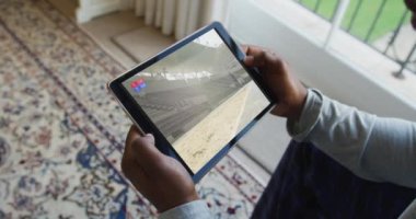 Adamın evde oturup tabletteki uzun atlama müsabakalarını izlemesi. spor, rekabet, eğlence ve teknoloji konsepti dijital olarak oluşturulmuş video.