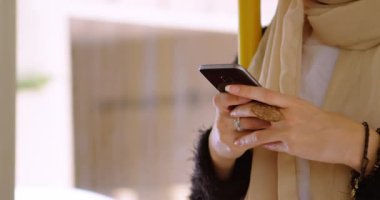 Şehir manzarası üzerinde akıllı telefon kullanan Asyalı kadın animasyonu. iletişim teknolojisi ve iletişimi sürdürmek, dijital olarak oluşturulmuş video.