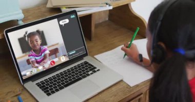 Liseli kız evde online ders için dizüstü bilgisayar kullanıyor, kız kıza konuşuyor ve ekranda sohbet ediyor. iletişim teknolojisi ve çevrimiçi ilköğretim konsepti, dijital kompozit video.