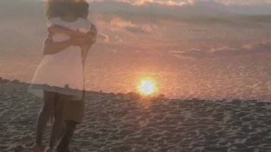 Sahilde gün batımında sarılan Afro-Amerikan çiftin animasyonu. Birlikte boş zaman geçirmek, mutlu tatiller ve boş zaman, dijital olarak oluşturulmuş video.