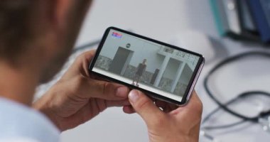 Atletizm müsabakalarını akıllı telefondan izleyen erkek doktorların birleşimi. spor, rekabet, eğlence ve teknoloji konsepti dijital olarak oluşturulmuş video.
