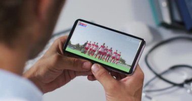 Erkek doktorun akıllı telefondan spor müsabakalarını izlemesinin birleşimi. spor, rekabet, eğlence ve teknoloji konsepti dijital olarak oluşturulmuş video.