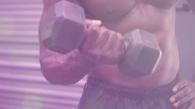 Spor salonunda egzersiz yapan güçlü bir adamın üzerinde parlayan noktaların animasyonu. spor, fitness ve aktif yaşam tarzı konsepti dijital olarak oluşturulmuş video.