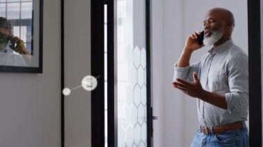 Afro-Amerikan kıdemli iş adamlarına karşı dijital ikonlar ağı ofiste akıllı telefondan konuşuyor. küresel ağ ve iş teknolojisi kavramı